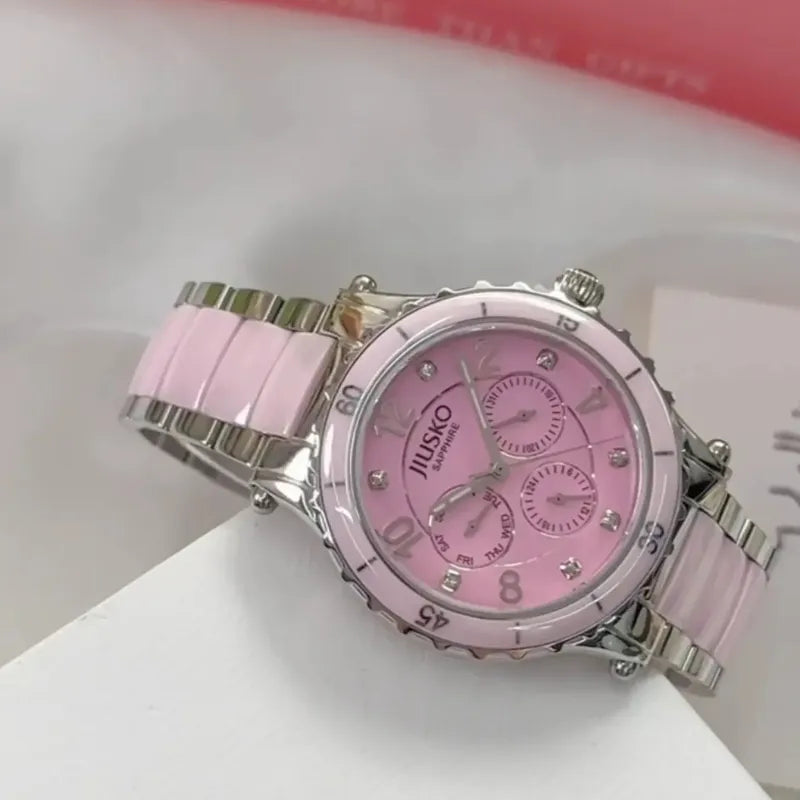 Pink watch with silver accents on a white surface