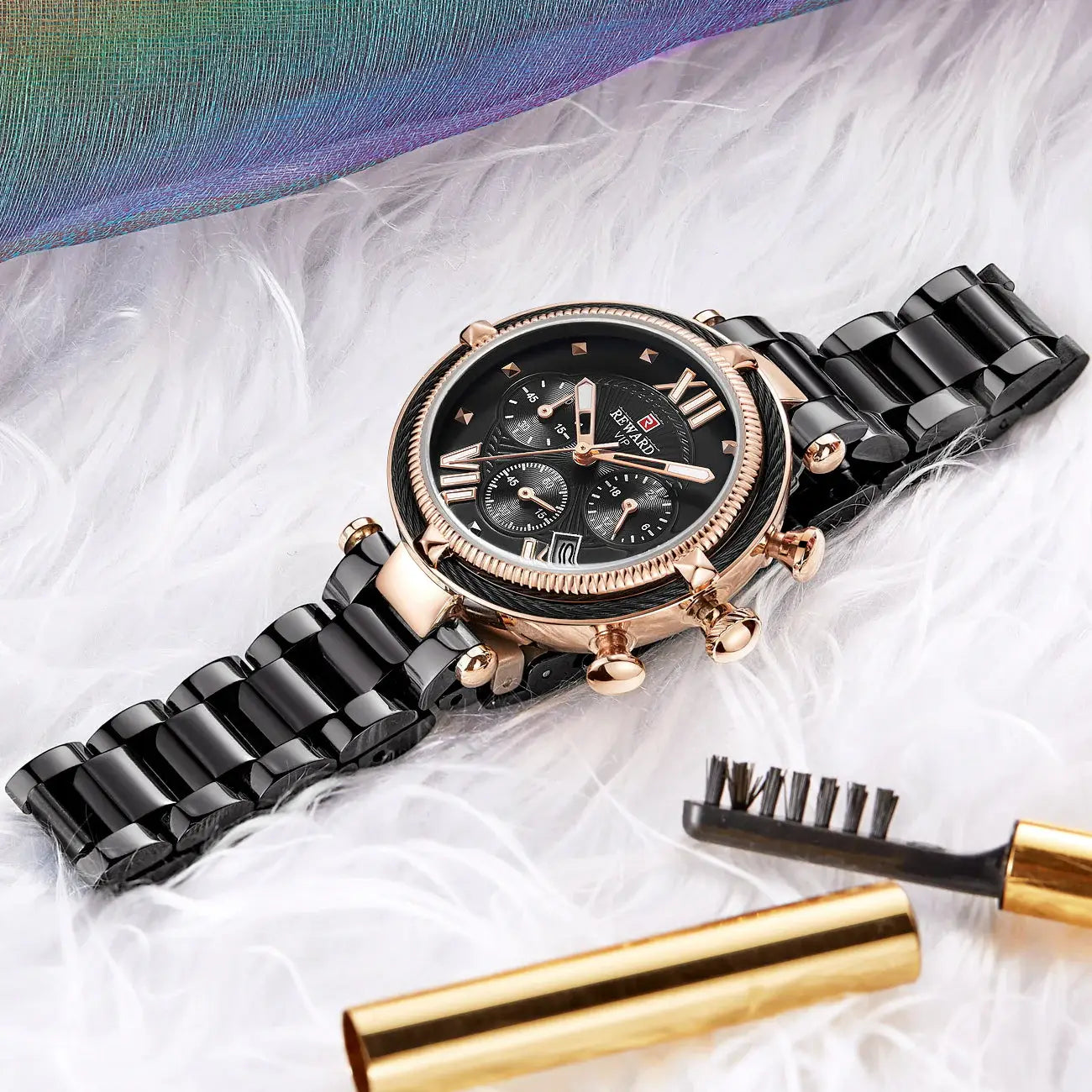 Black and rose gold watch with makeup brush and mascara on a white background