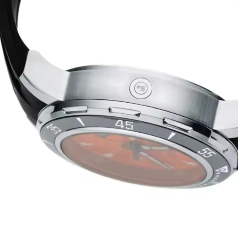 Close-up of a watch with a metallic band and red face on a white background