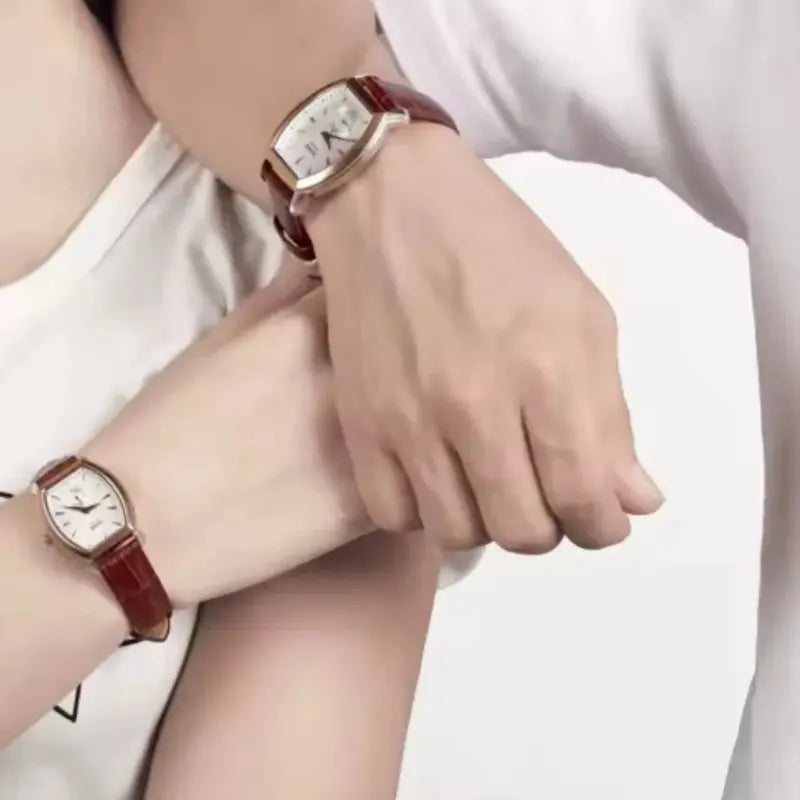 Two wrists wearing red wristwatches on a white background