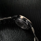 Close-up of a watch on a textured black surface