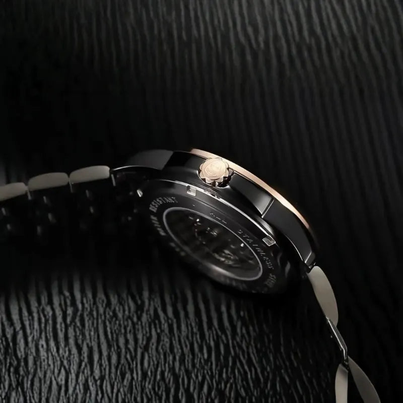 Close-up of a watch on a textured black surface