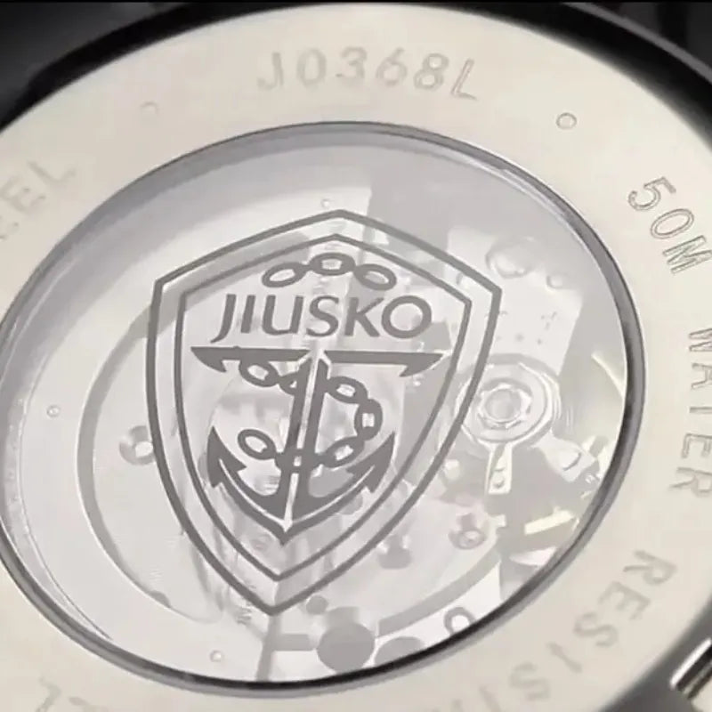 Close-up of a watch with JIUSKO branding and anchor design.