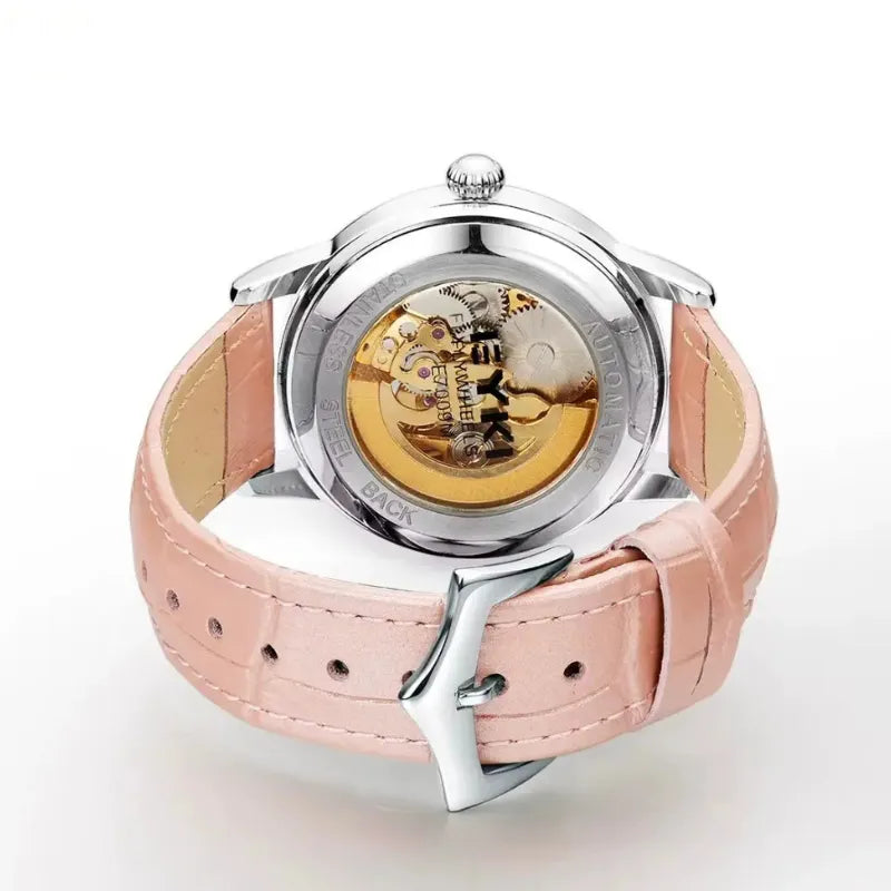 Watch with pink leather strap and visible mechanical components on a white background