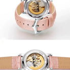 Watch with pink strap and visible mechanical components on a white background