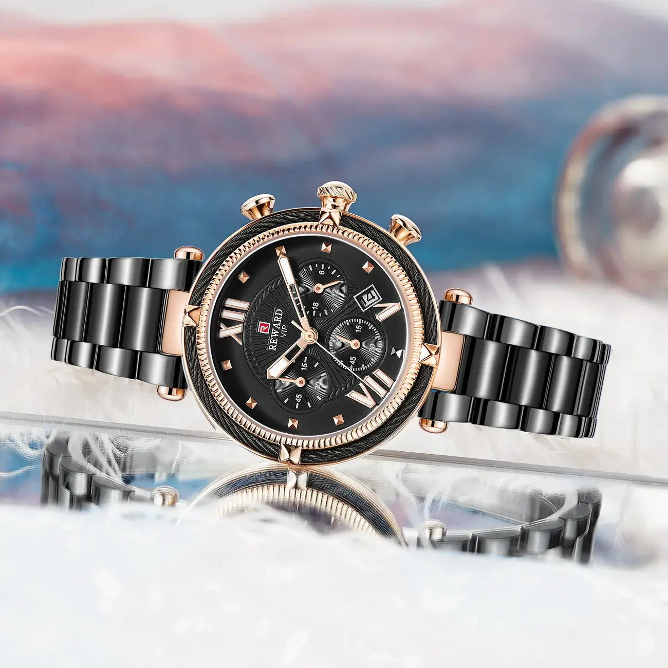 Luxury watch with black and rose gold design on a reflective surface with a blurred background
