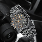 Black wristwatch with detailed face on a blurred background