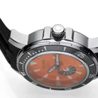 Close-up of a watch with an orange face on a white background