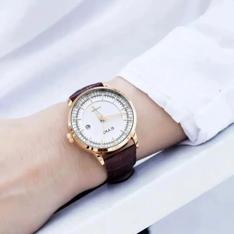 Wrist wearing a watch with a brown strap and rose gold case on a white background