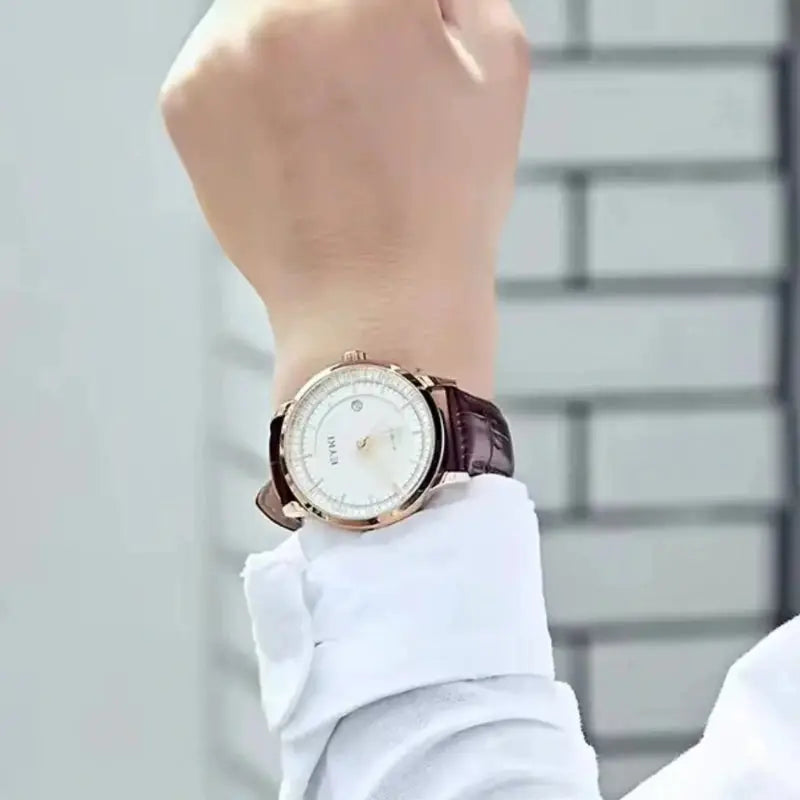 Hand wearing a wristwatch with a blurred background