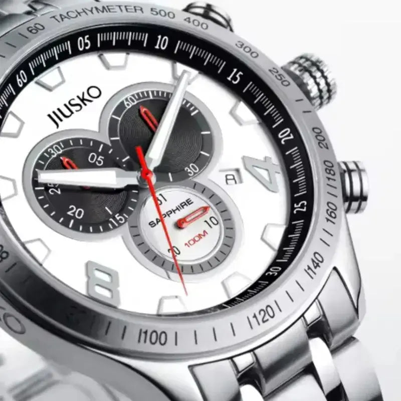 Close-up of a silver watch with black face and red accents, brand 'JIUSKO' visible.