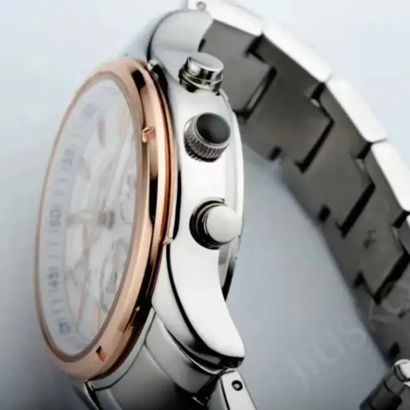 Close-up of a silver watch with a rose gold bezel on a light gray background