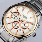 Silver and rose gold watch with white face on a light gray background